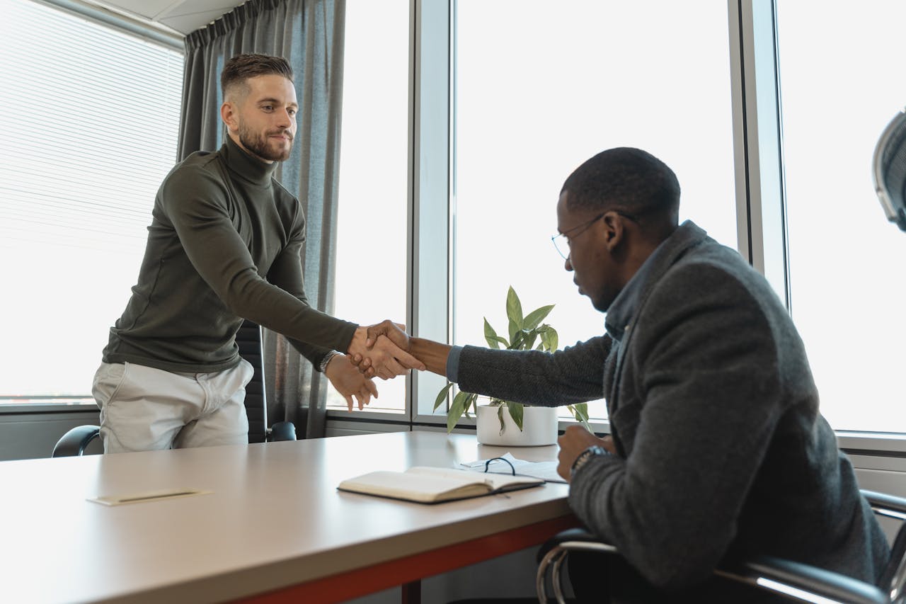 Mastering the First Impression: Your intriguing post title goes here Two businessmen shaking hands in a modern office after a successful meeting or interview.