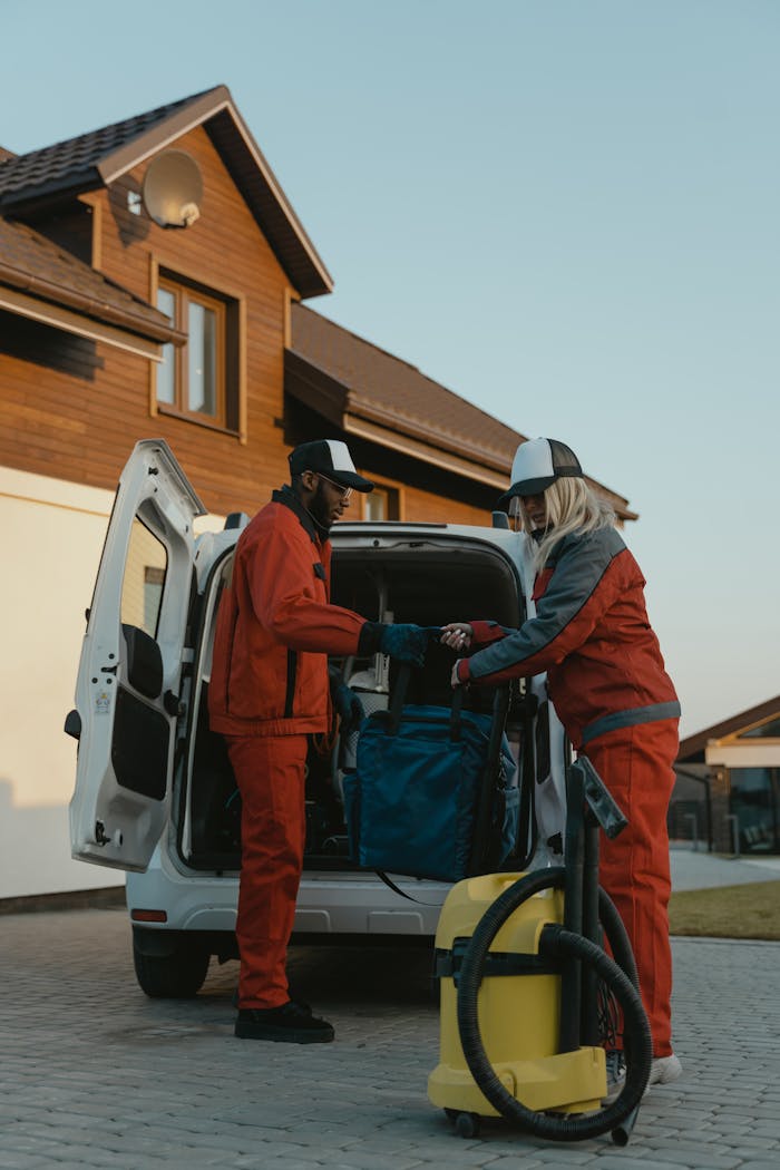 The Art of Drawing Readers In: Your attractive post title goes here Two professional cleaners in work uniforms unloading equipment from a van in a residential area.